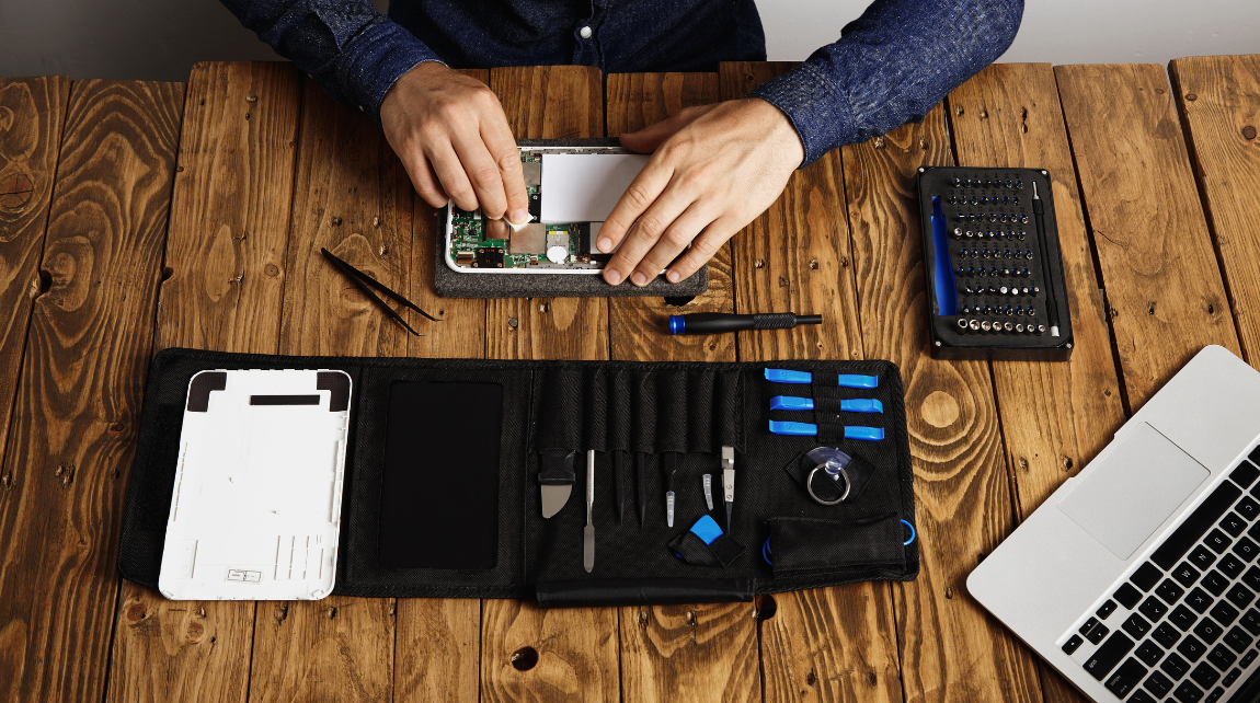 Technician repairing a laptop at the workbench